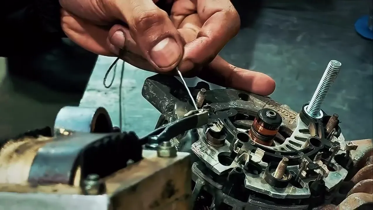 Alternador aberto durante o reparo, com regulador e porta-escovas à mostra